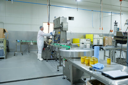 Worker operating machinery in a clean manufacturing facility for Malnad Gidda A2 Cow Ghee production.